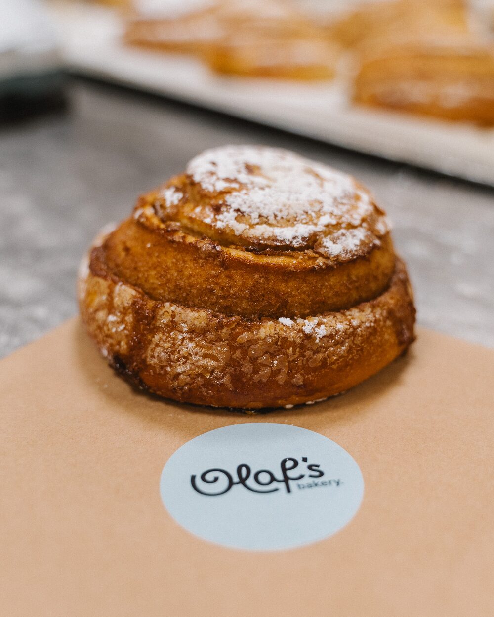 Zimtschnecke aus einem Probelauf in der Produktion, davor der Kleber von Olaf's Bakery
